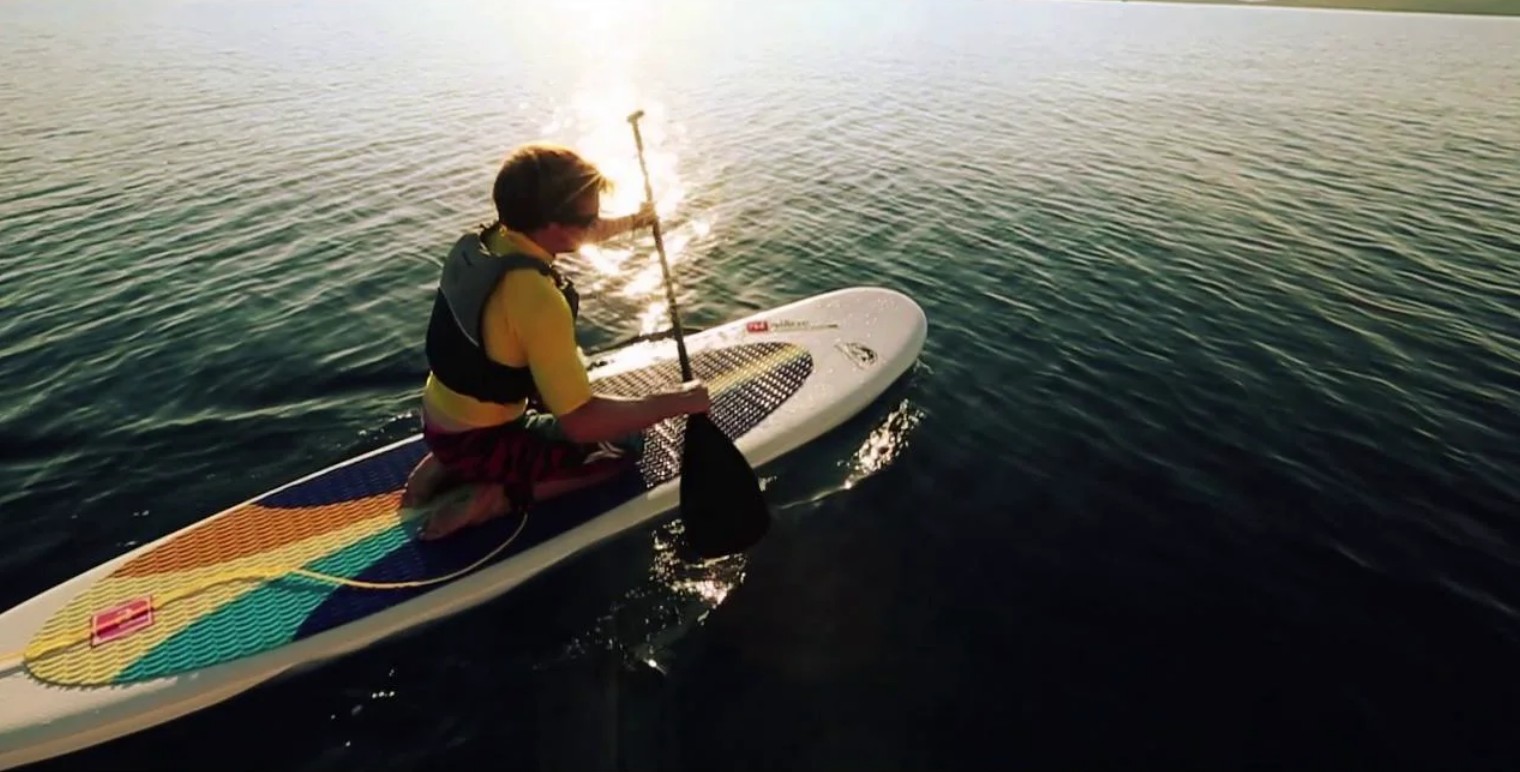 Paddle board prepared with paddle and leash for a safe start